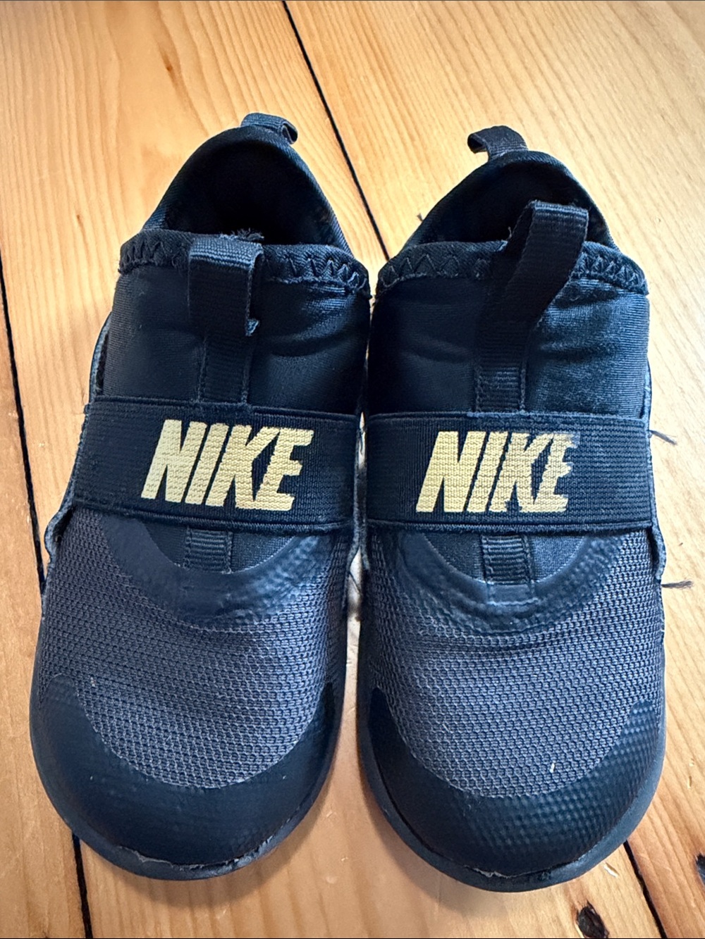 Nike Kids Black Slip-On Sneakers with Gold Logo Strap